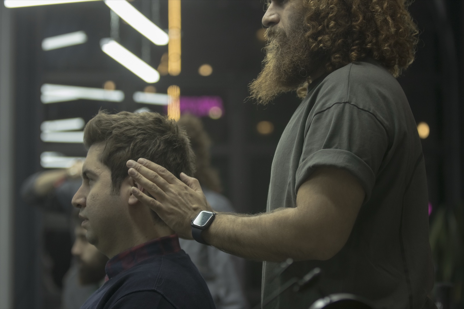 Peluquero que acomoda el pelo de un cliente